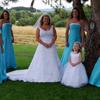 bridesmaids in teal blue dresses, flower girls in white dresses. Yellow and orange flowers