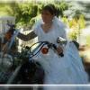 Bride on Harley Davidson in formal wedding gown.
